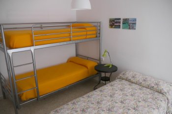 Dormitorio con cama litera y cama individual.