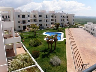 Zona ajardinada y piscina.