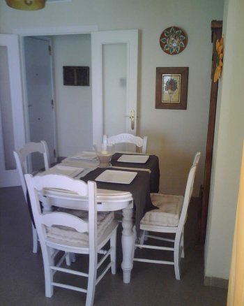 Detalle del salón con mesa y sillas